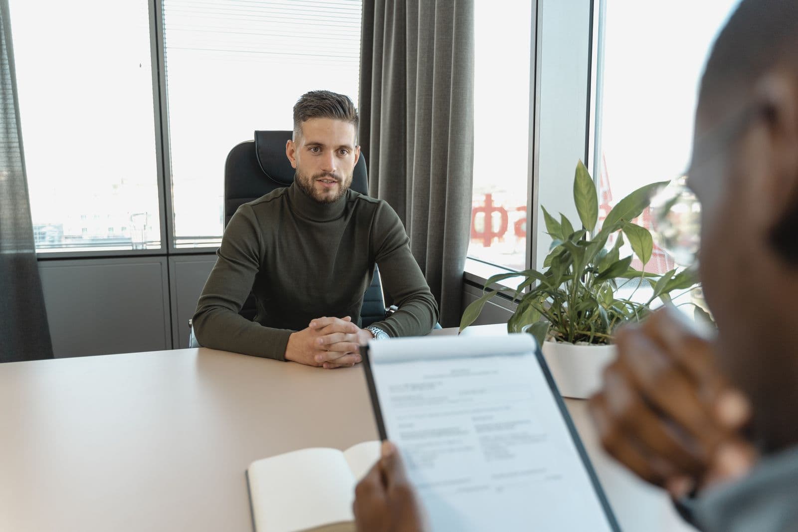 Two people conducting a job interview across a meeting table
